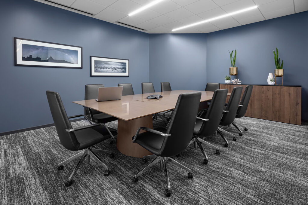 Professional conference room with wood meeting table, executive chairs, and framed wall artwork