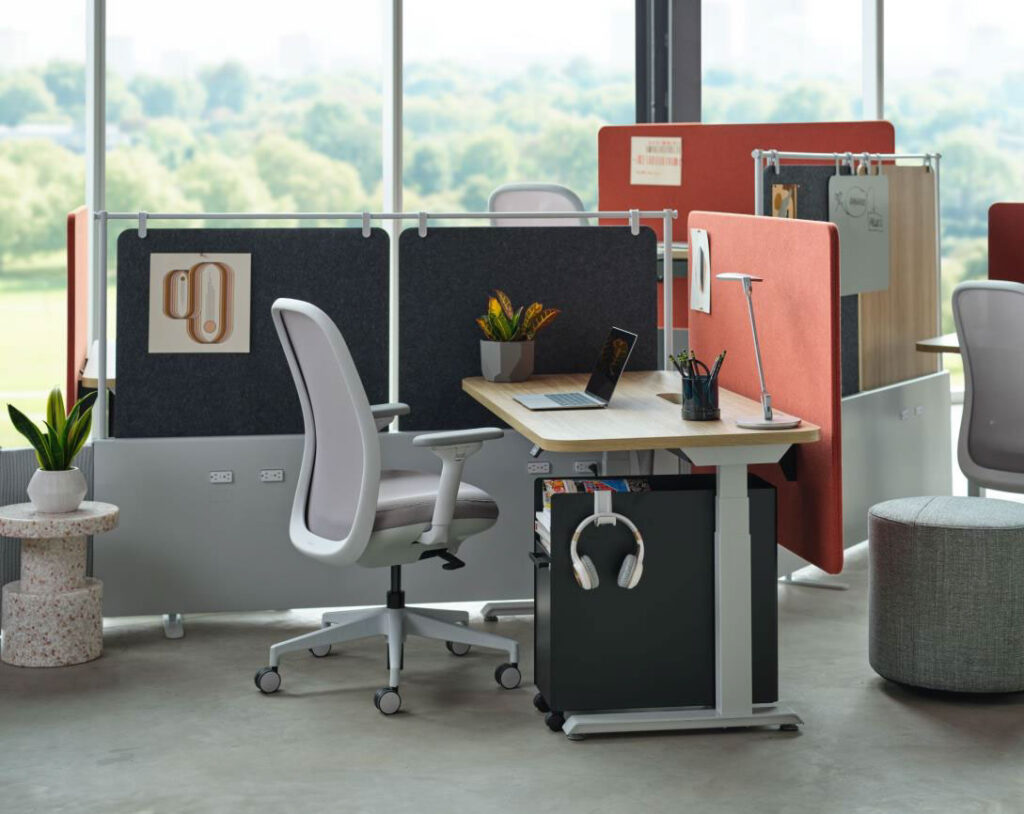 Height-adjustable office workstation with ergonomic chair, monitor, storage, and privacy screens