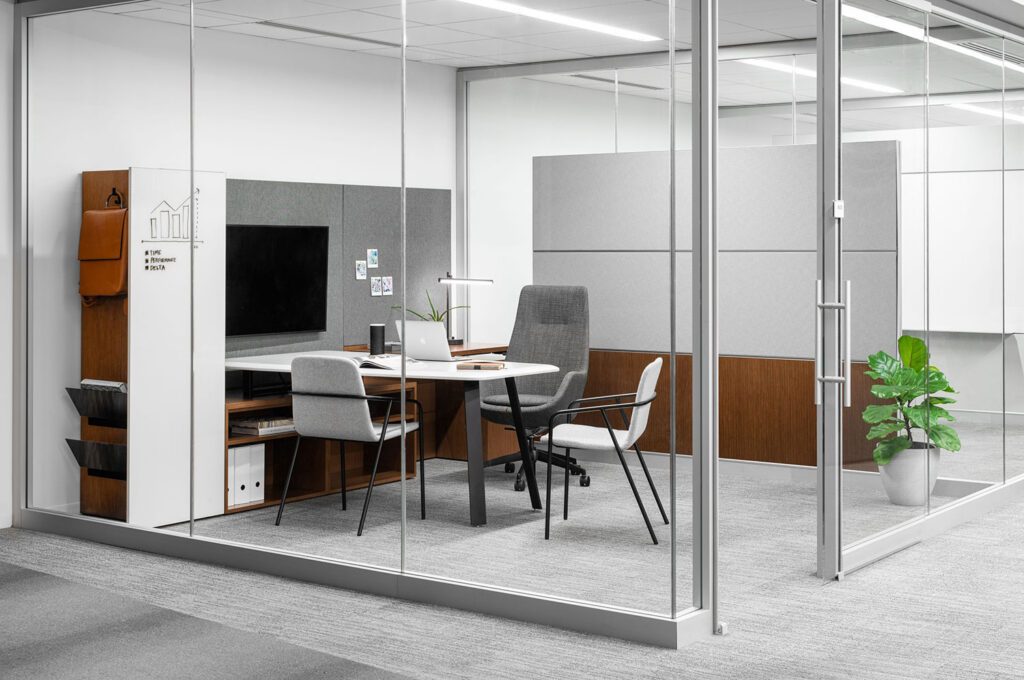 Glass-walled corporate meeting room with wood table, white chairs, and modern office furnishings