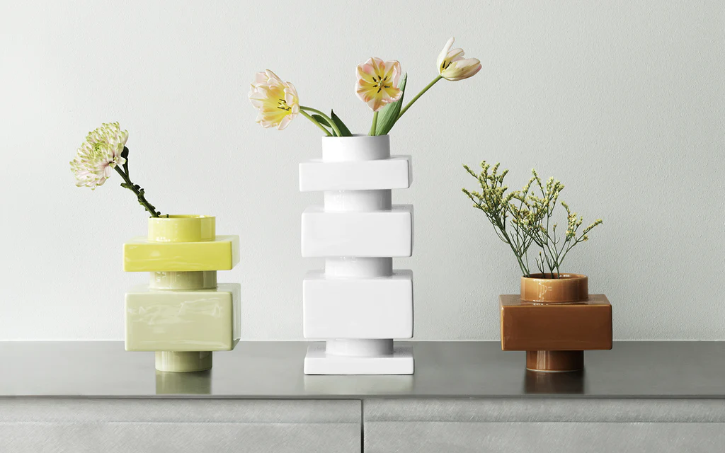 White Deko decorative objects arranged with flowers and greenery on a modern tabletop
