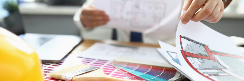 Workplace design consultation with floor plans, finish samples, and commercial interior materials