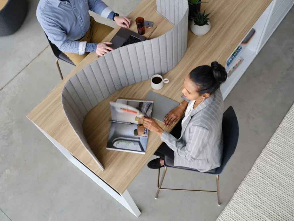 Overhead view of employees using a curved acoustic workspace with integrated privacy and storage