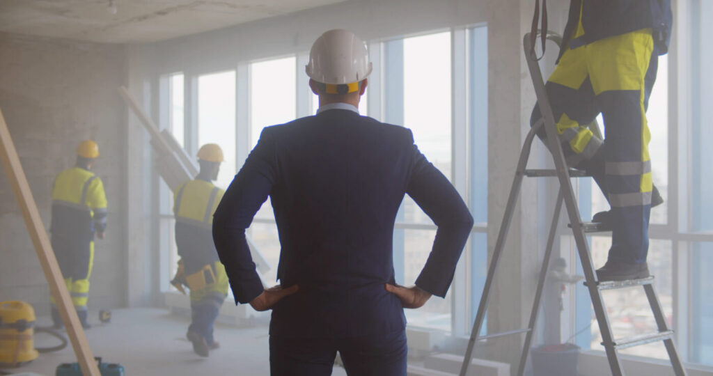 Commercial construction professional wearing a hard hat while reviewing an office interior project