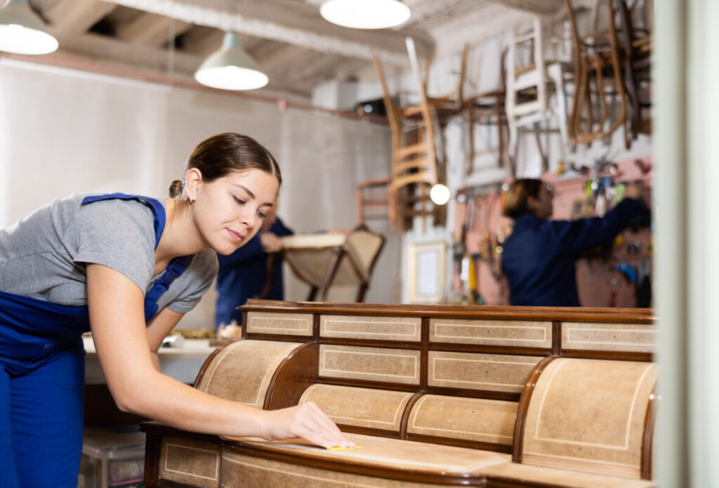 MBI's Craftsperson refurbishing wood office furniture as part of a commercial furniture restoration service