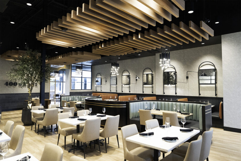 Workplace café with linear wood acoustic ceiling baffles, pendant lights, and communal tables