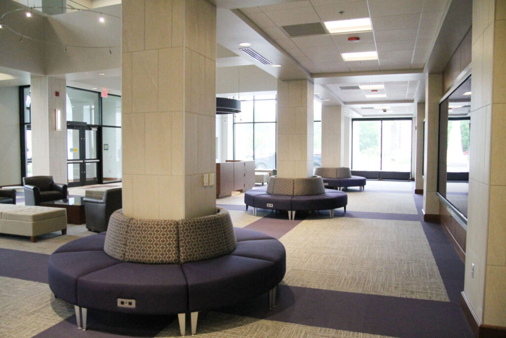 Curved upholstered seating arranged around structural columns in a bright public waiting area