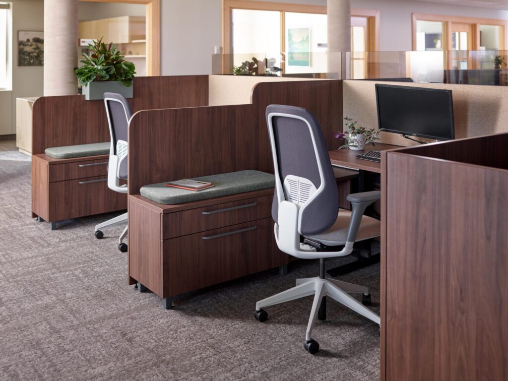 OFS private office with a wood desk, high-back upholstered seating, and an ergonomic task chair