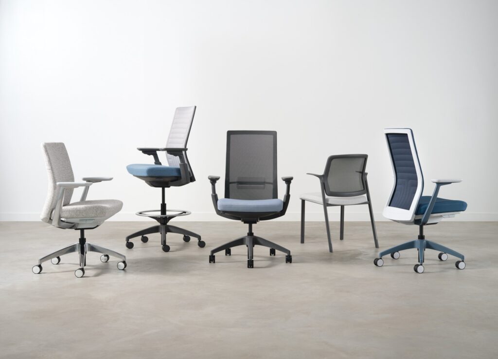 Five modern ergonomic office chairs with varied mesh backs, upholstered seats, adjustable arms, and rolling bases.