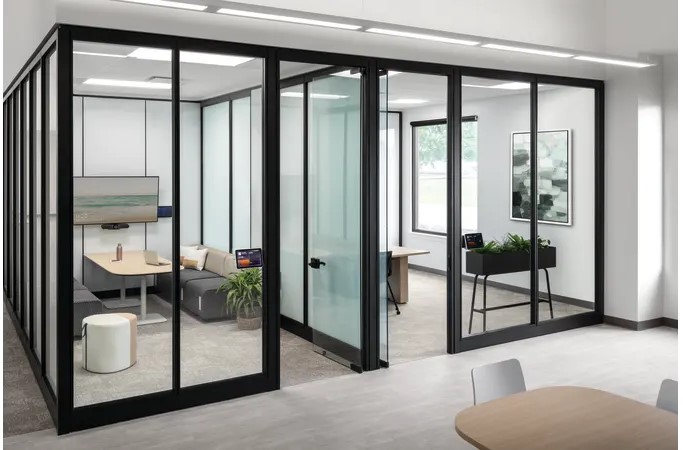 Modern modular office with black-framed glass walls, private meeting rooms, lounge seating, and integrated technology.