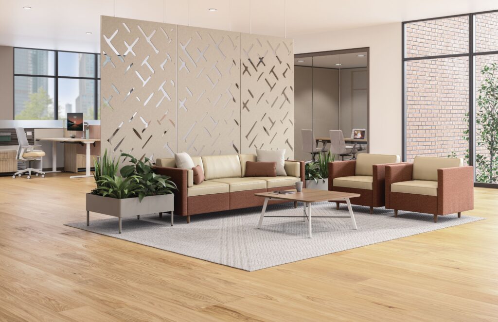 Modern office lounge with sofas, armchairs, planter boxes, a coffee table, and suspended decorative acoustic panels.