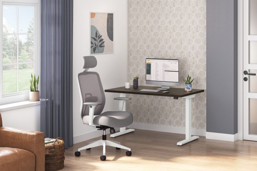 Modern home office with a height-adjustable desk, ergonomic chair, desktop monitor, indoor plants, and a patterned accent wall.