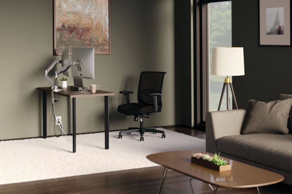 Comfortable home office with a dual-monitor desk, ergonomic chair, floor lamp, sofa, and large window.